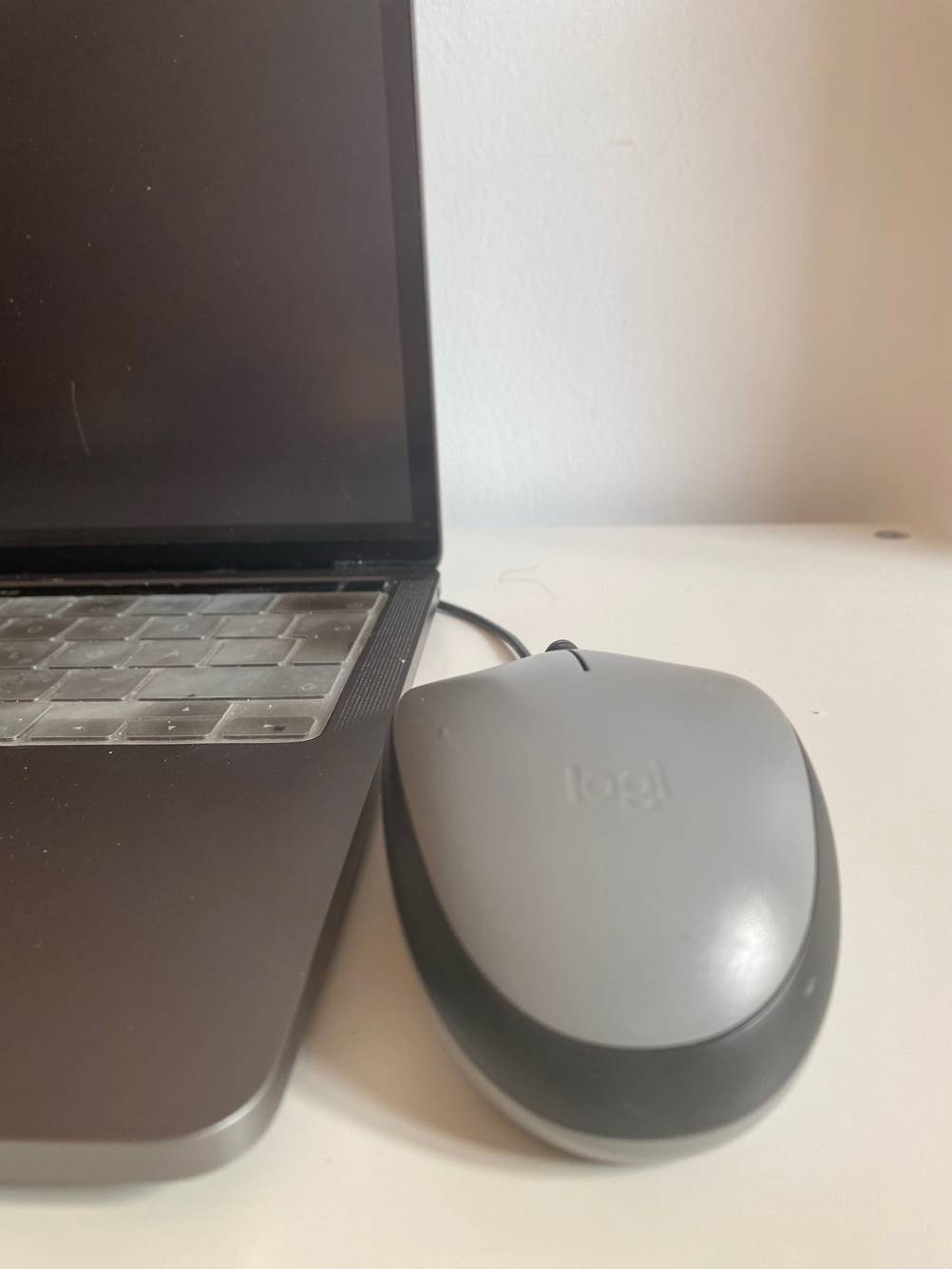 Eine graue Computer Maus angeschlossen am Laptop