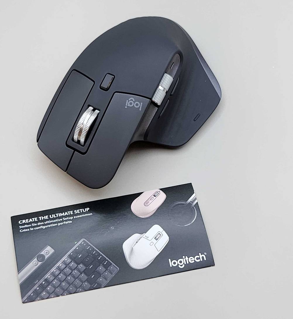 Eine getestete ergonomische Maus liegt neben der Produktbeschreibung auf einer weißen Oberfläche.