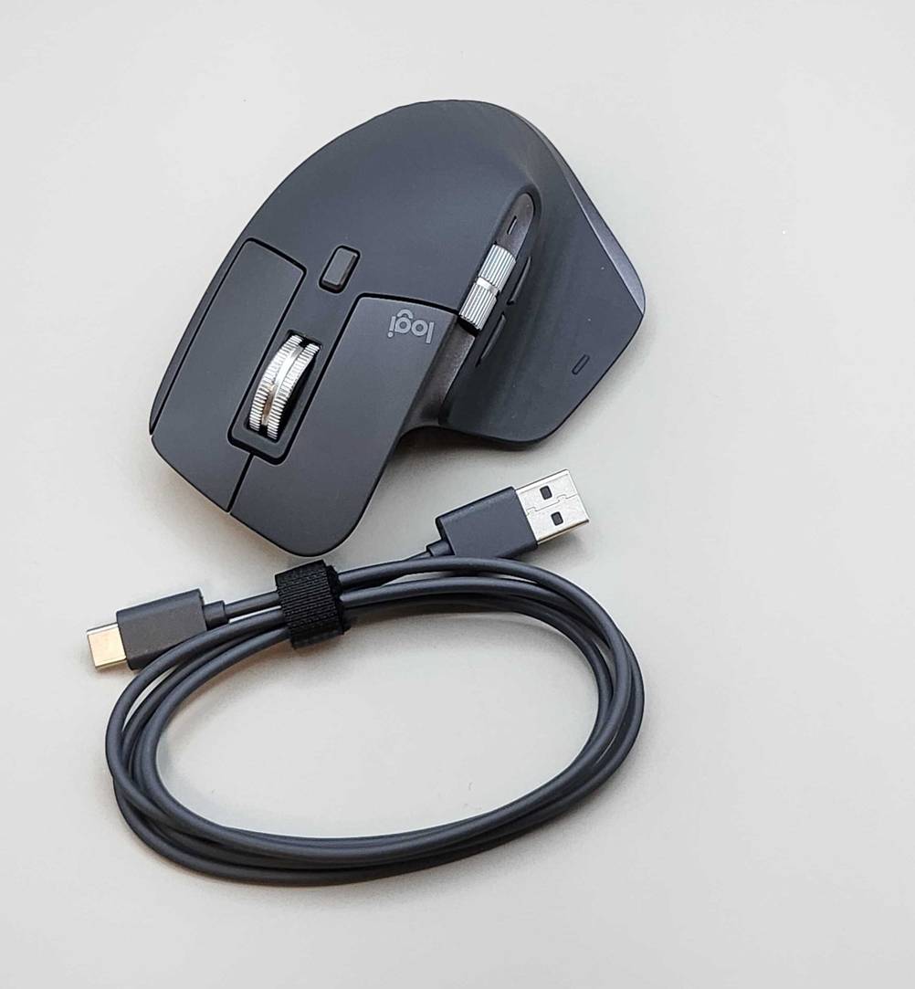Getestet: Eine ergonomische Maus liegt hinter einem aufgerollten USB-Kabel auf einer weißen Oberfläche.