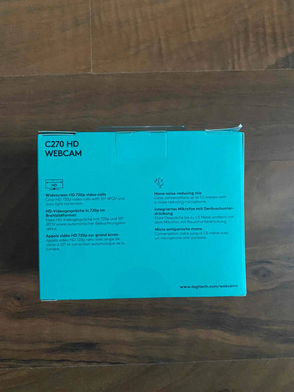 Logitech-Webcam getestet: Rückseite der Packung auf einem Holztisch liegend.