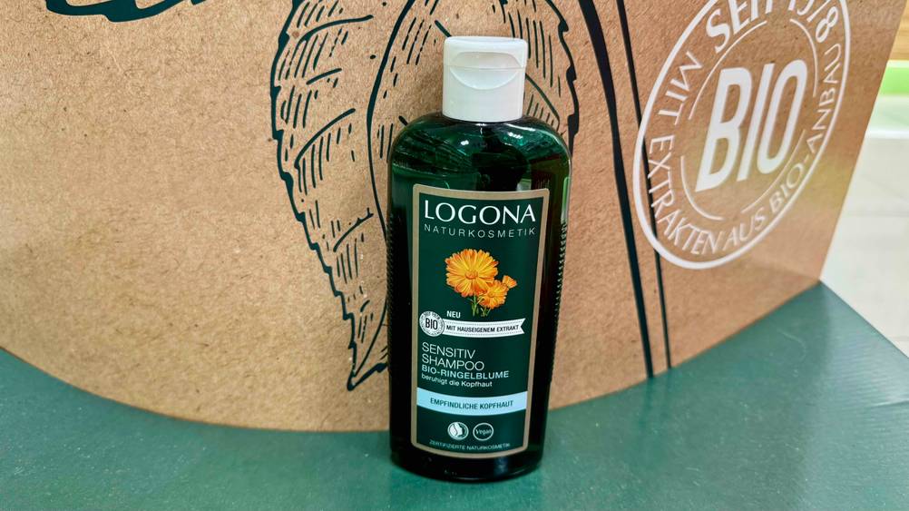 Vor einem Plakat steht das Logona-Shampoo im Test.