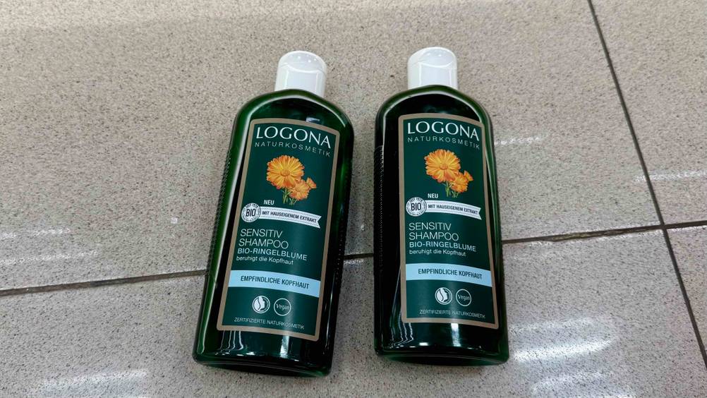 Logona-Shampoo im Test: Zwei Flaschen nebeneinander auf einem Fließenboden.