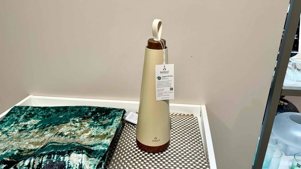 Eine beigefarbene Edelstahl-Trinkflasche im Test steht auf einem Verkaufsregal.