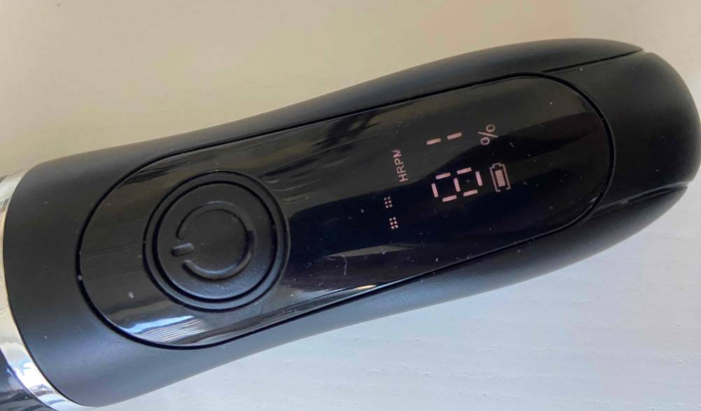 Haarschneideset im Test: Detailansicht der Einschalttaste sowie der LCD-Anzeige mit Temperaturangabe eines schwarzen Modells.