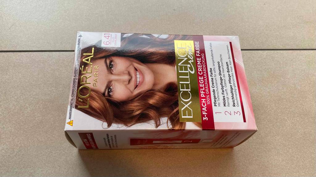 L’Oréal Haarfarbe getestet: Packung mit Farbe 6.41 liegt quer auf hellem Hintergrund.