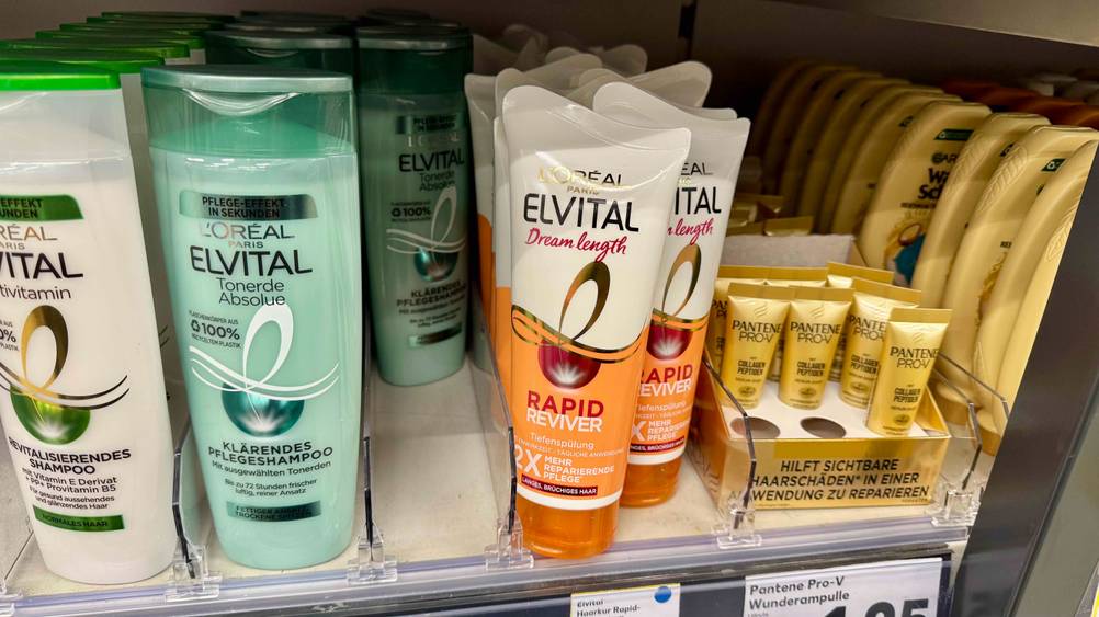 Mehrere Tuben der L'Oreal-Haarkur im Test in einem Regal neben anderen Produkten.