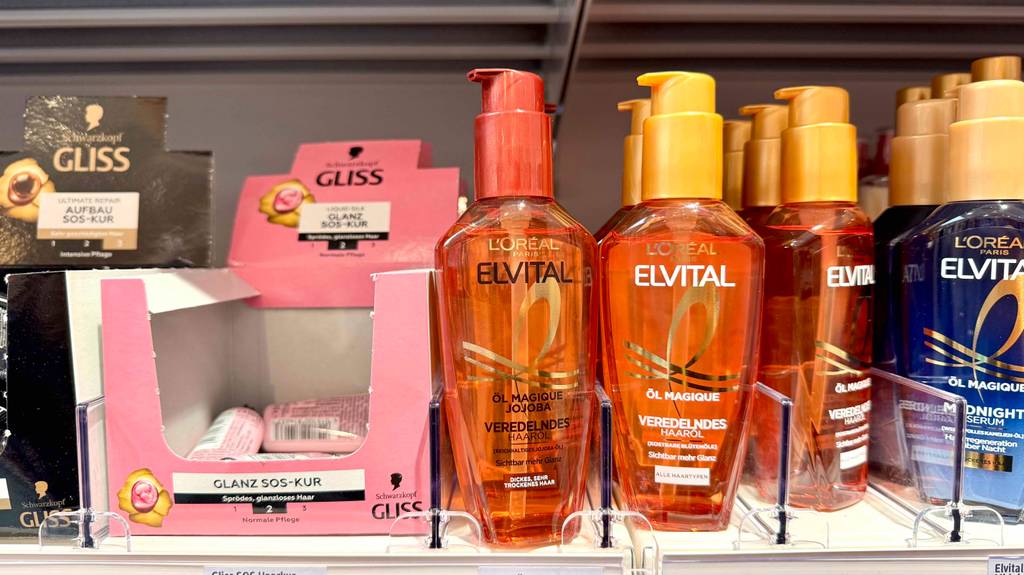 Loreal-Haarpflege im Test: Mehrere Flaschen unterschiedlicher Varianten stehen zwischen anderen Pflegeprodukten in einem Regal.