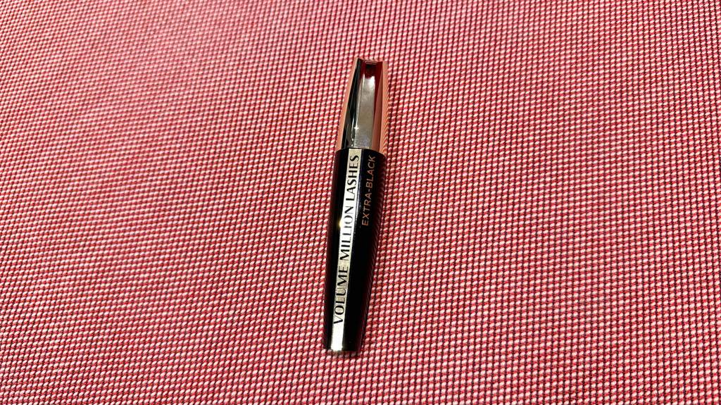 Eine getestete Loreal-Mascara liegt auf einer roten Fläche.