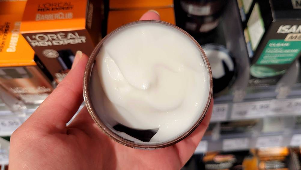 Pomade getestet: In einer Hand befindet sich eine geöffnete Dose mit Inhalt.