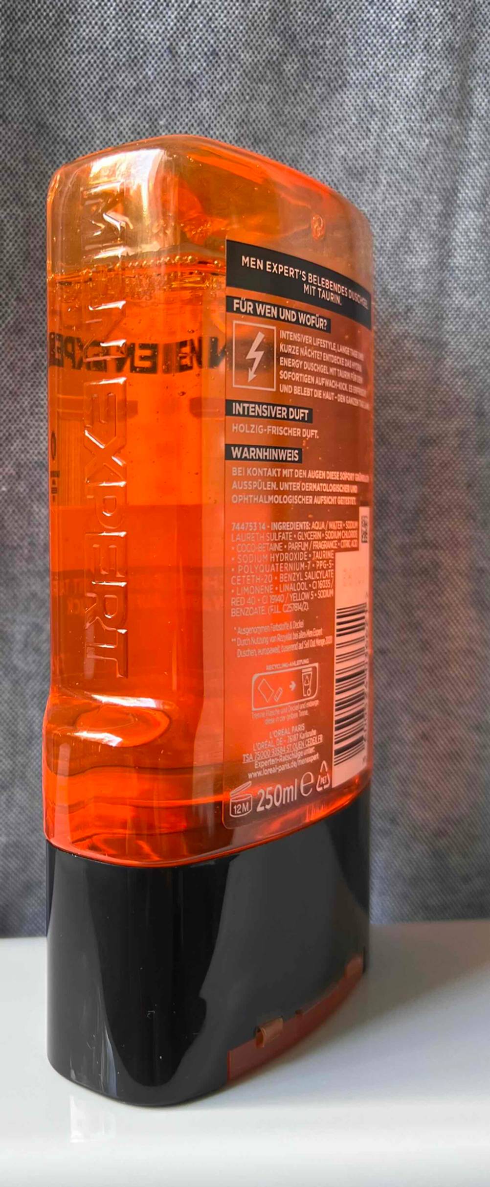 Auf einer hellen Fläche vor einer grauen Wand steht seitlich eine Flasche Bartshampoo im Test.