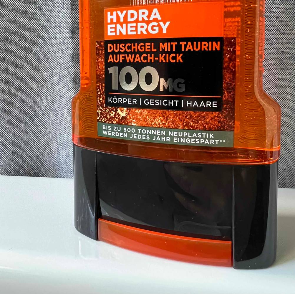 Nahaufnahme des Verschlusses und des Labels einer Flasche des getesteten Bartshampoos auf einer hellen Fläche.