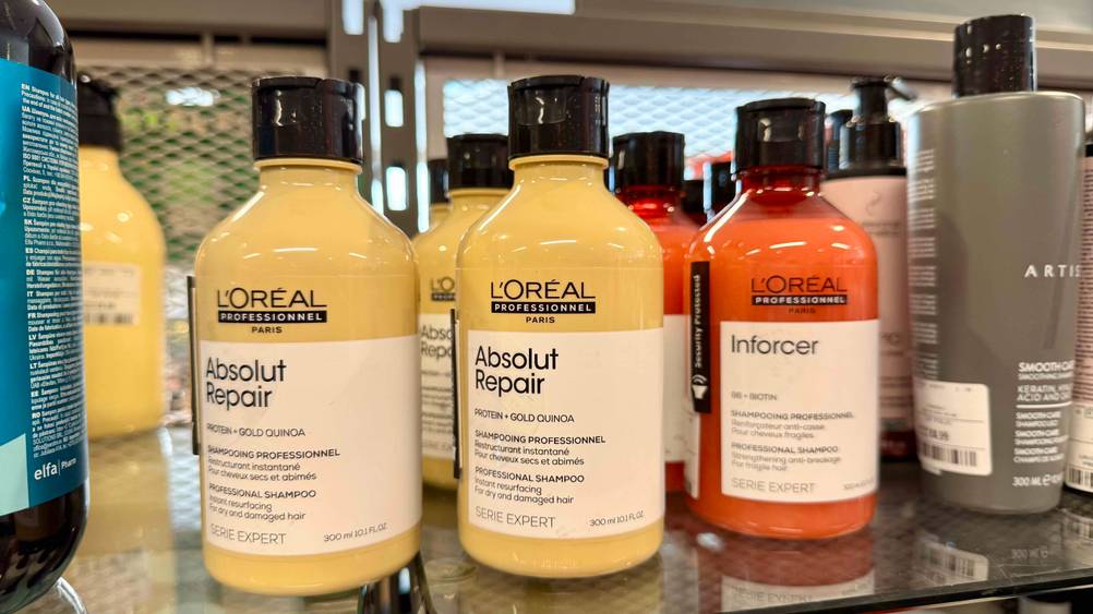 Mehrere Flaschen des L'Oréal-Professional-Shampoo im Test in einem Verkaufsregal stehend.