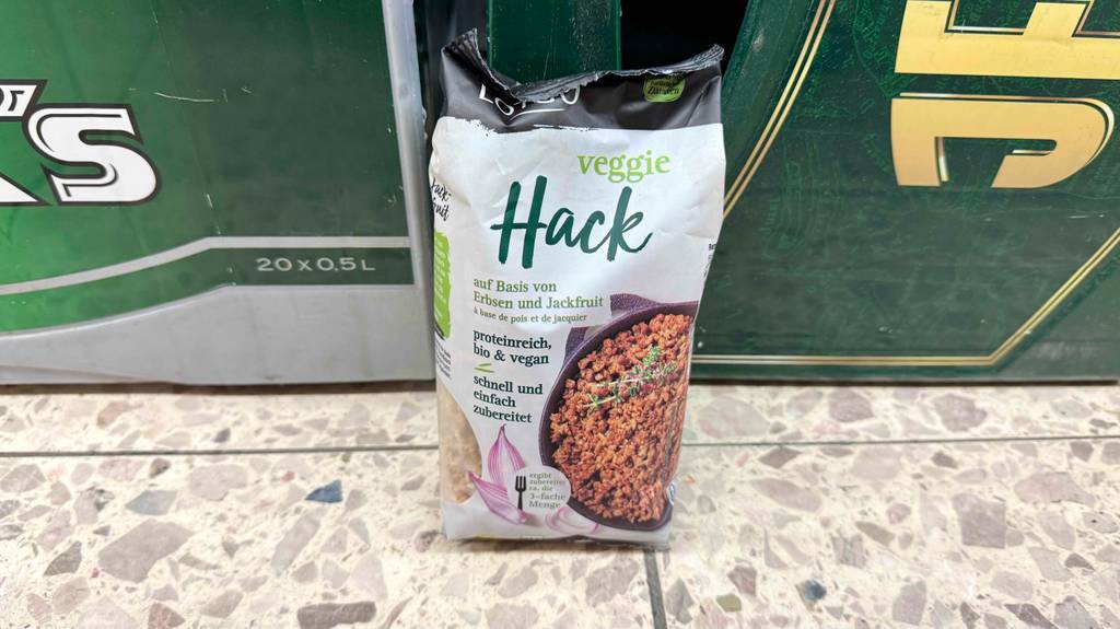 Getestet: Veganer Hack im Beutel steht vor einer Bierkiste.