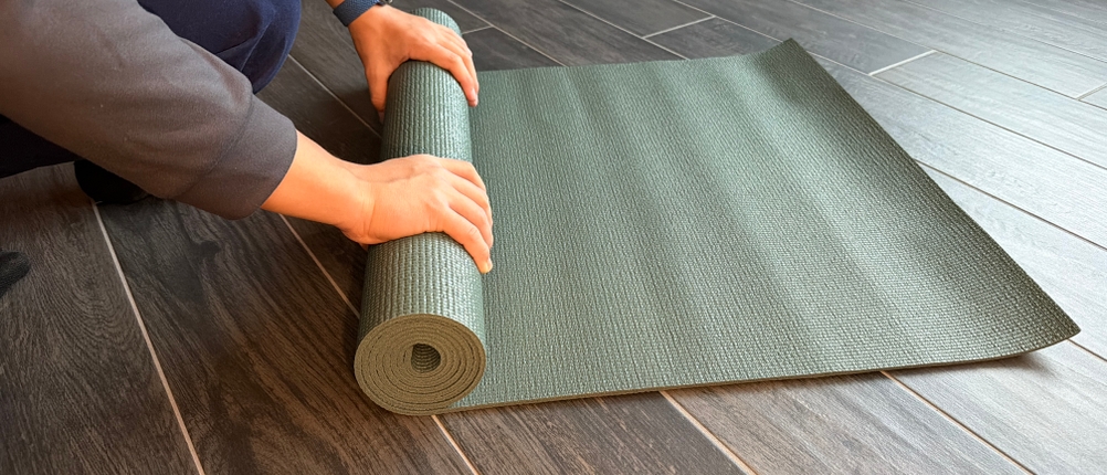 Eine Person rollt die Lotuscrafts Mudra Studio zusammen