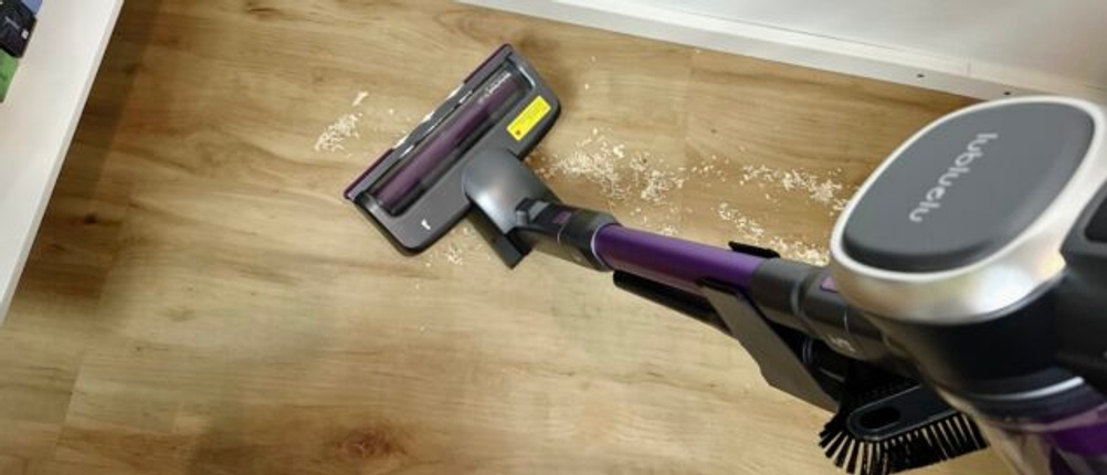 Der Lubluelu 25000Pa Akkustaubsauger reinigt einen Holzboden mit verstreutem Schmutz.