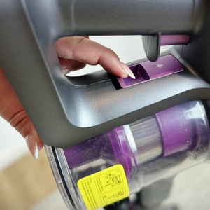 Eine Person drückt die Entriegelungstaste des Lubluelu 25000Pa, um den Staubbehälter zu entnehmen.