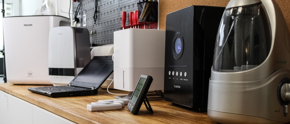 Mehrere getestete Luftbefeuchter stehen auf einer Werkbank nebeneinander