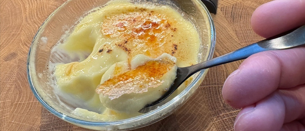 Auf einem Löffel liegt Crème Brûlée