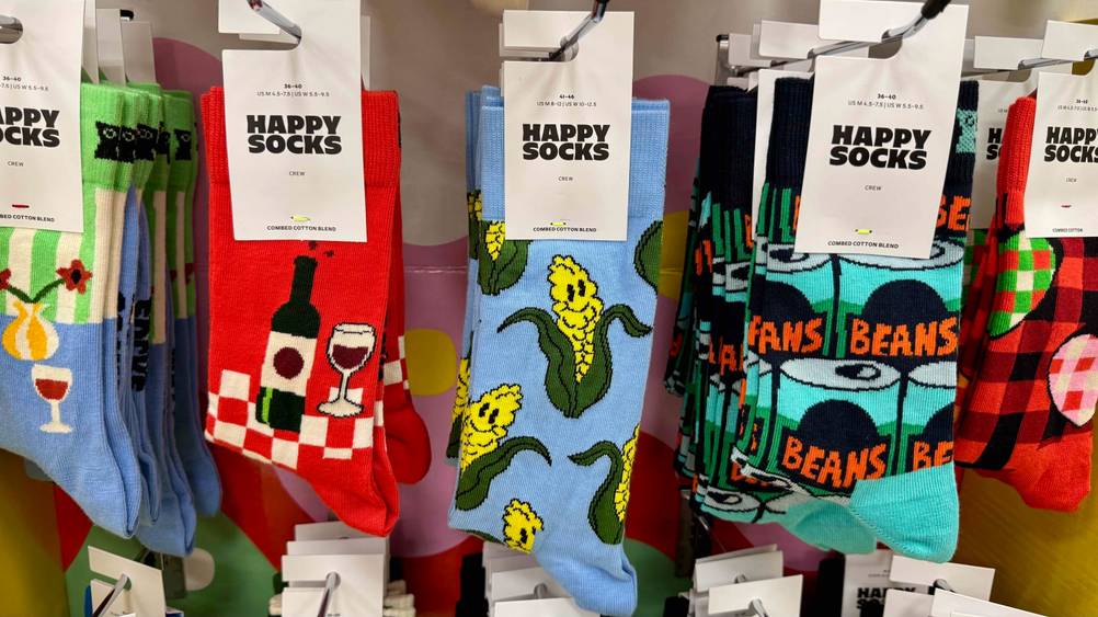 Lustige Socken getestet: Mehrere Paare hängen in einem Verkaufsregal.