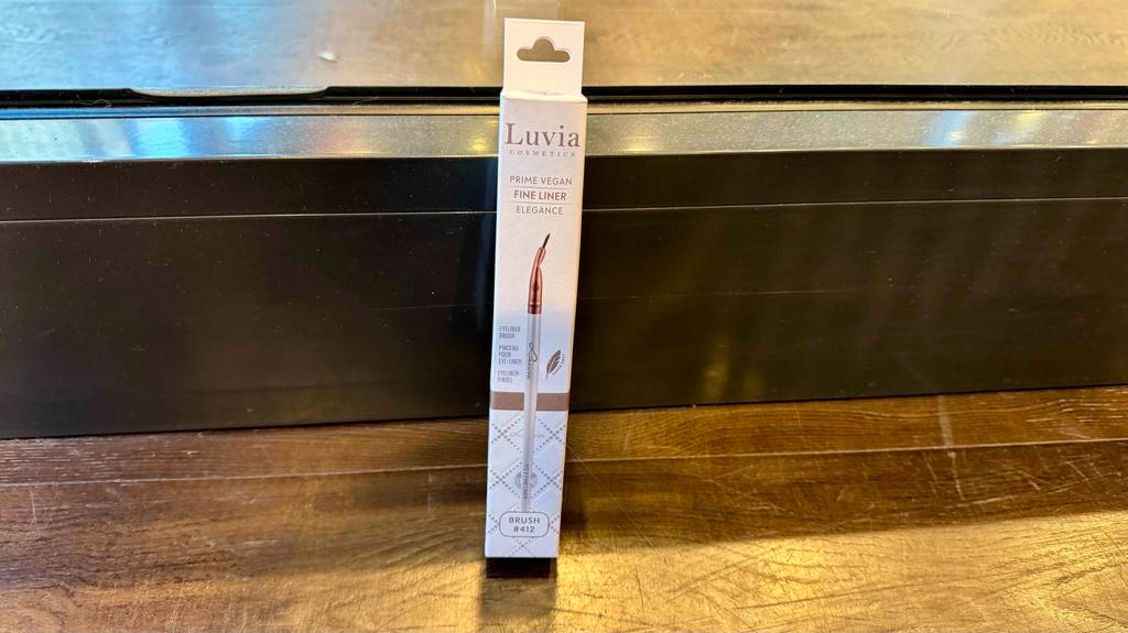 Eyeliner-Pinsel im Test: Ein veganer Pinsel in der weißen Verpackung lehnt vor einem Verkaufsregal.