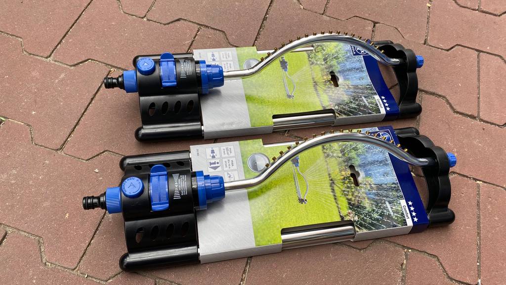 Comfort-Viereckregner im Test: zwei Viereckregner inklusive Verpackung liegen auf einem Terrassenboden.