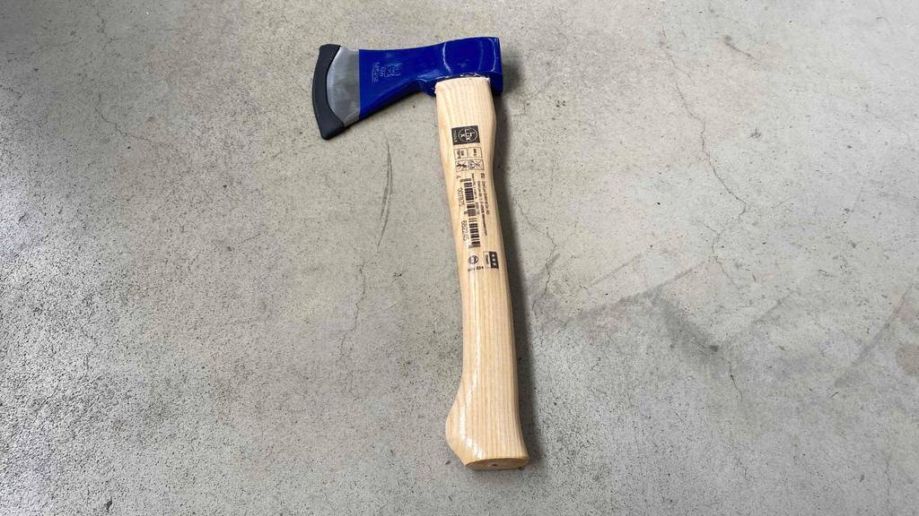 Ein getestetes Handbeil auf einer Betonfläche.