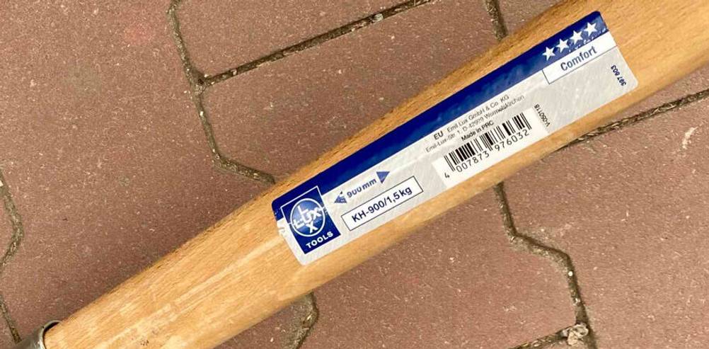 Detailansicht einer getesteten Kreuzhacke inklusive Produktetikett auf dem Holzstiel.