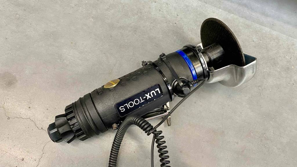 Schlagschrauber-Test: ein schwarzes Lux-Tool befindet sich gesichert an einer hellen Ausstellungswand.