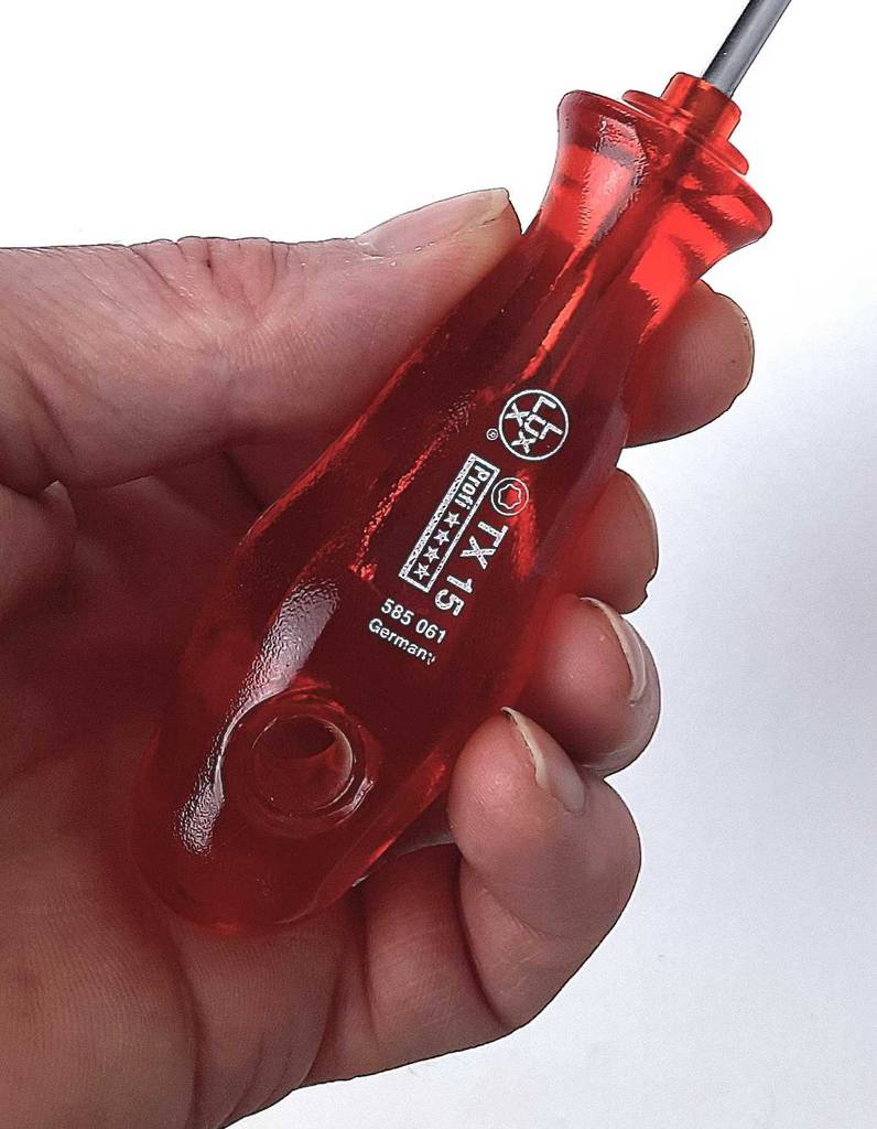 Schraubendreher im Test: Ein Modell mit rotem Griff wird in einer Hand gehalten.