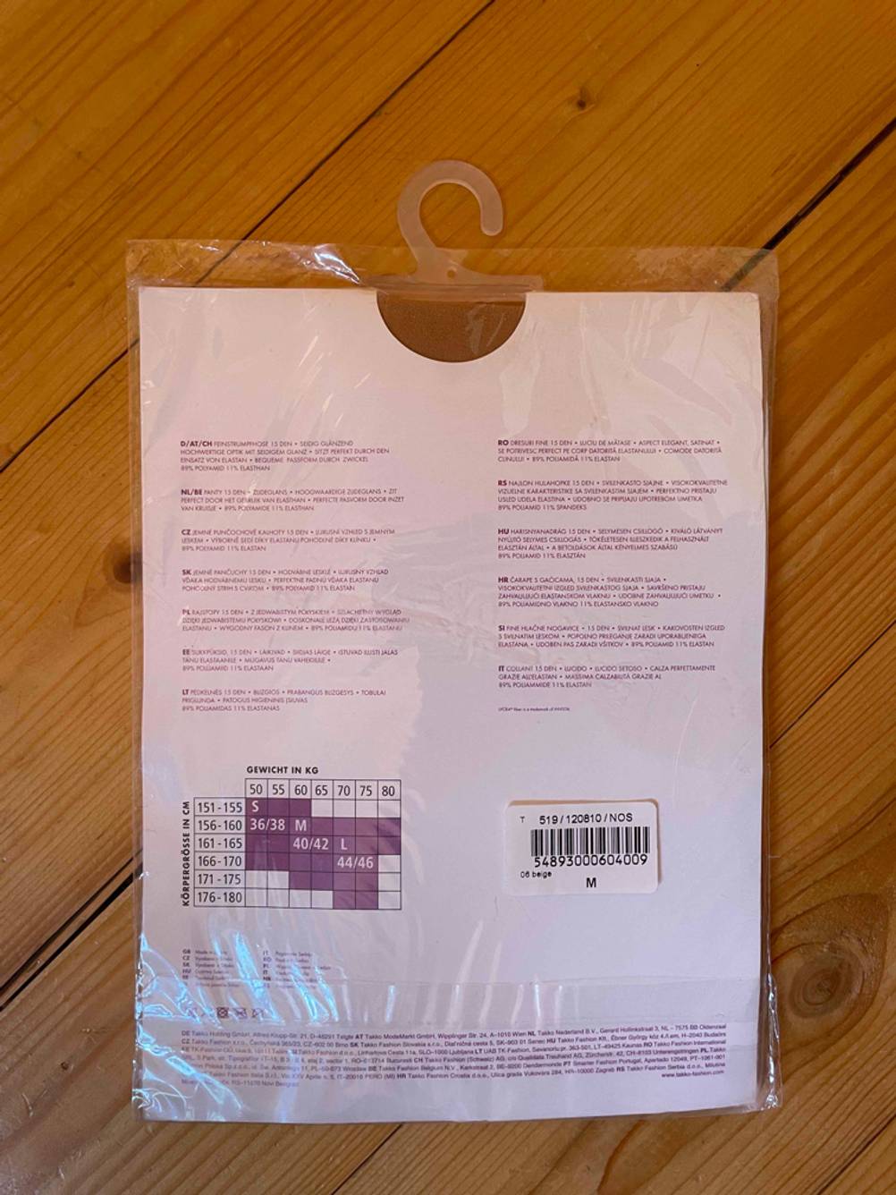Strumpfhose im Test: Rückseite einer verpackten Strumpfhose liegt auf Holzboden.