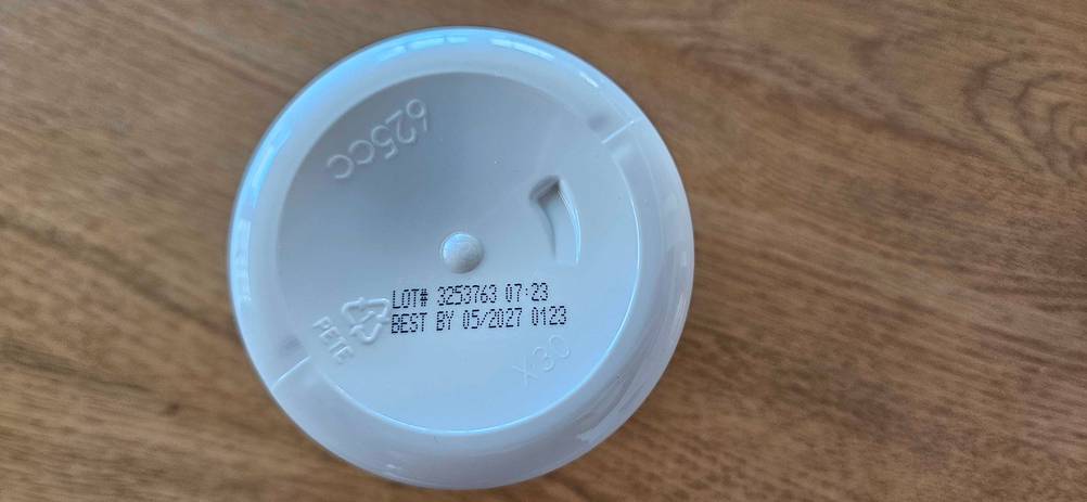 Mehrere Lysin-Tabletten im Test: Auf einem Tisch steht eine Lysin-Verpackung mit Mindesthaltbarkeitsdatum.