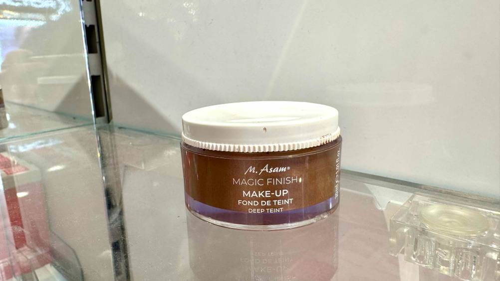 Getestet: Eine Dose des M.-Asam-Make-ups steht auf einem Glasregal.