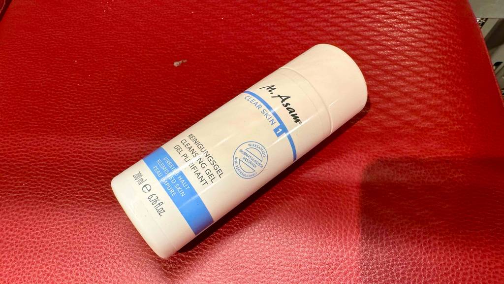 Getestet: Ein Reinigungsgel in einer weißen 200-ml-Kunststoffflasche liegt auf einem roten Lederuntergrund.
