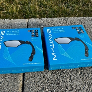 Die Kartons der M-Wave-SPY-Space-Fahrradspiegel in Schwarz liegen auf einem Stein.