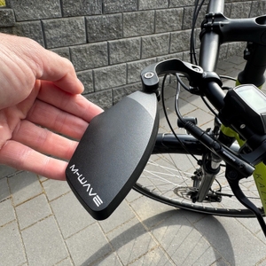 Eine Hand dreht den M-Wave-SPY-Space-Fahrradspiegel in Schwarz nach unten.
