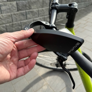 Eine Hand dreht den M-Wave-SPY-Space-Fahrradspiegel in Schwarz nach innen.