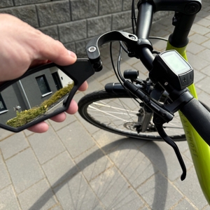 Eine Hand dreht den M-Wave-SPY-Space-Fahrradspiegel in Schwarz nach außen.