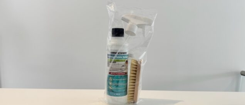 Macari-Polsterreiniger steht in einer Plastikverpackung mit Bürste und Sprühkopf auf einer Ablage.