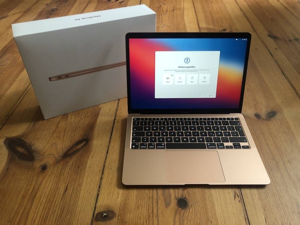 Ein getesteter MacBook Air liegt aufgeklappt auf Holzboden.