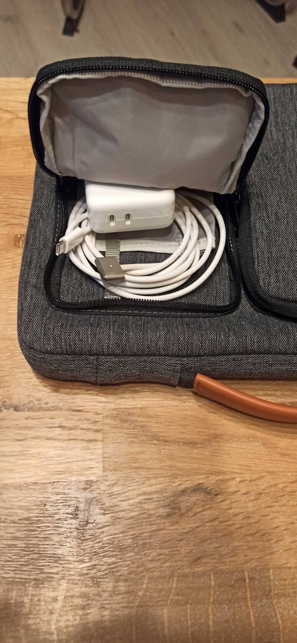 Seitentasche einer Macbook-Tasche mit Ladegerät.