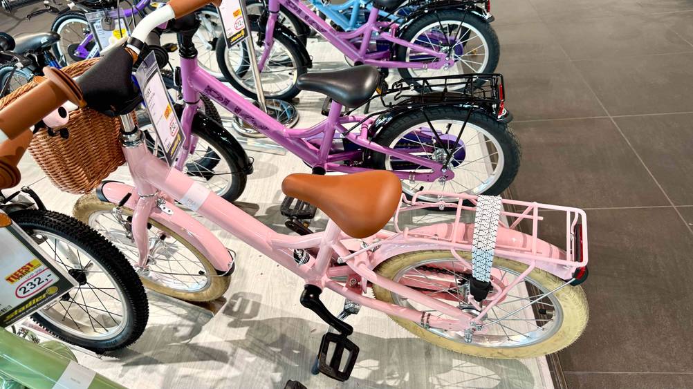 Ein getestetes Mädchenfahrrad 16 Zoll neben anderen in einer Ausstellung.