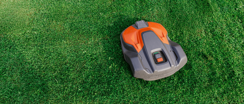 Mährobter ohne Begrenzungskabel im Test: Ein Mähroboter steht auf einer Rasenfläche.