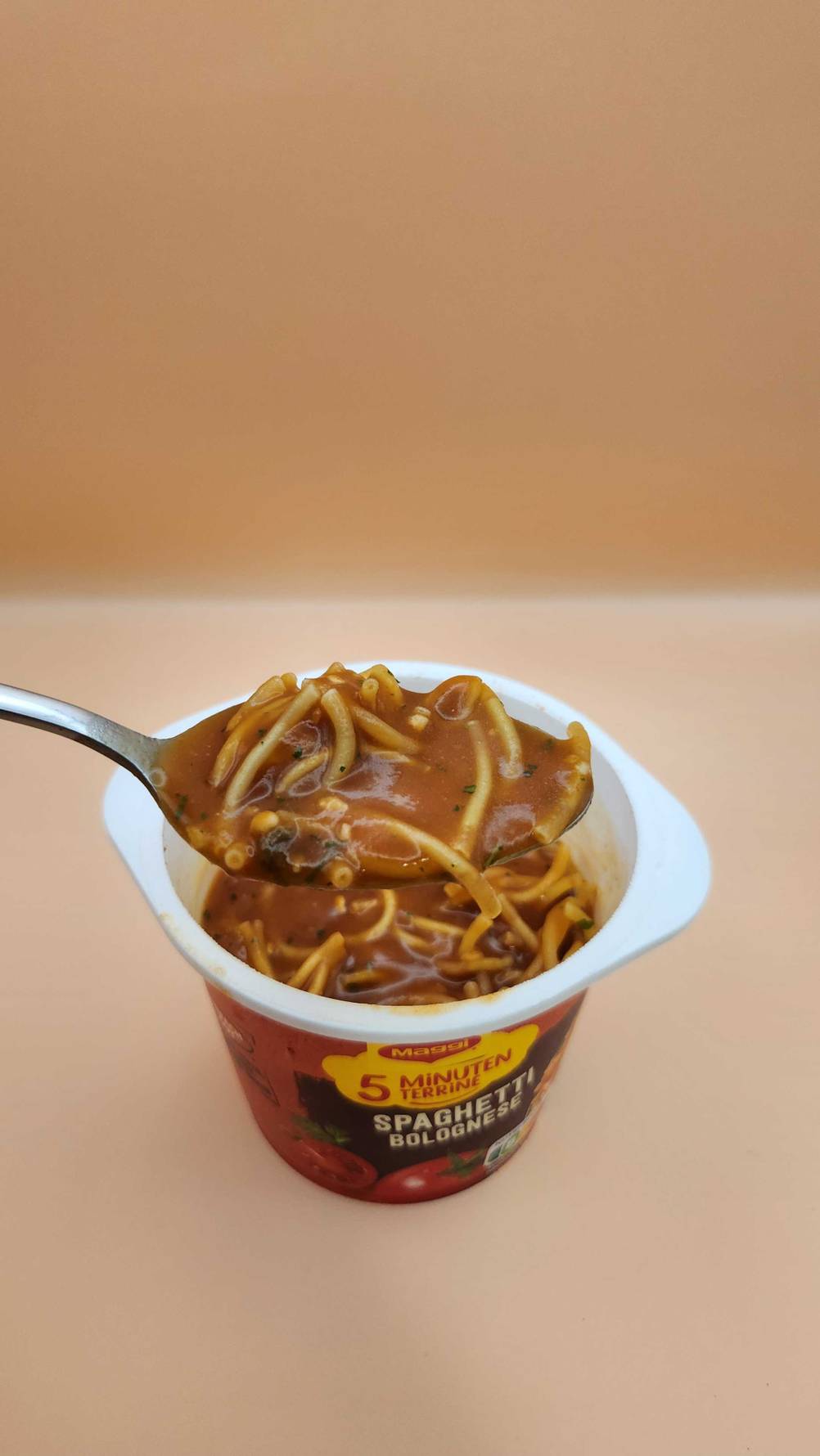 Maggi-5-Minuten-Terrine-Test: Nahaufnahme eines Löffels mit Nudeln, im Hintergrund der Becher.