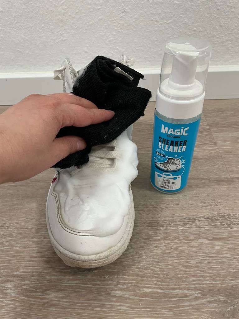 Im Test: Eine Hand putzt einen Schuh mit Sneaker-Cleaner.