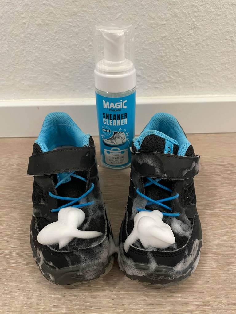 Eine Dose Sneaker-Cleaner steht getestet zwischen einem Paar Schuhe, die eingeschäumt sind.
