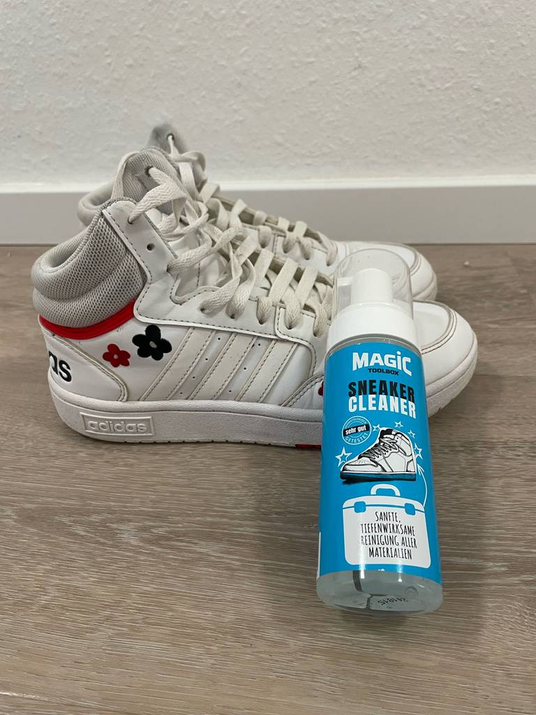 Eine Dose Sneaker-Cleaner liegt zum testen auf einem Paar weiße Turnschuhe.