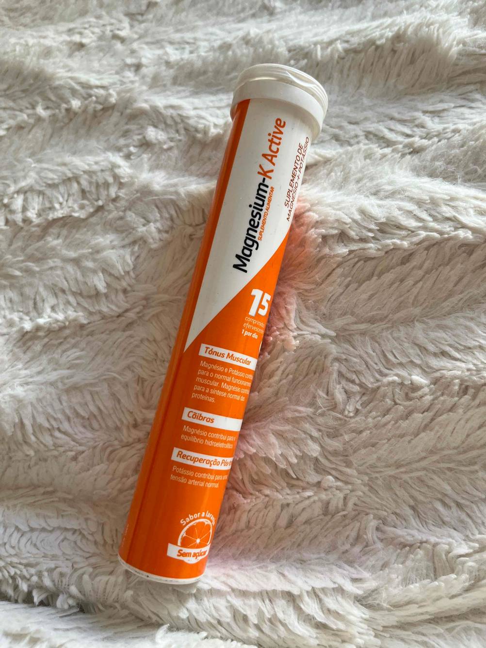 Im Test: Röhre mit Magnesium Brausetabletten liegt auf weißer Decke.