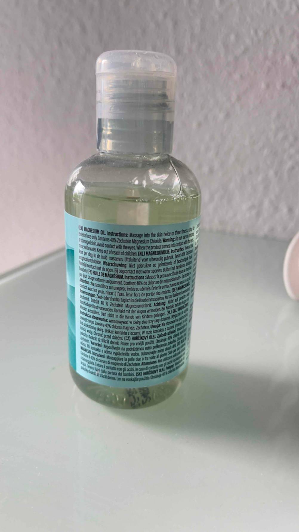 Detailansicht der Produktbeschreibung auf dem Etikett der transparenten Flasche mit dem getesteten Magnesiumöl.