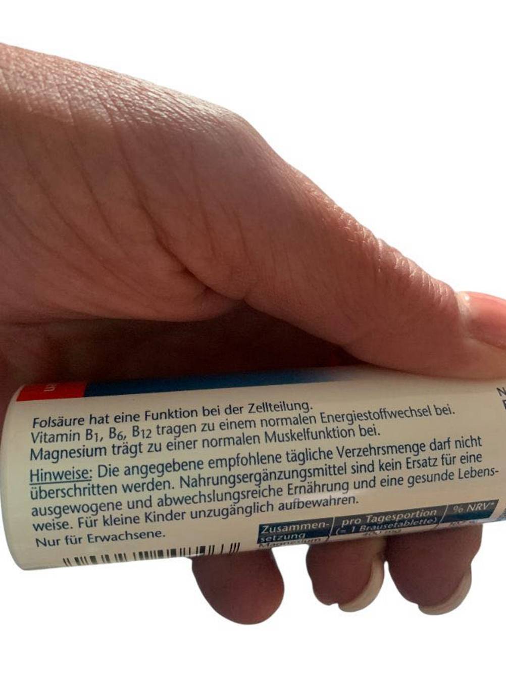 Eine Hand hält die Packung des getesteten Magnesiumpräparates so, daß man die Hinweise auf der Packung sieht.