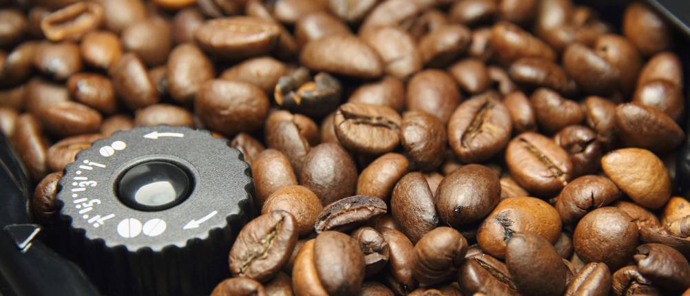 Bosch-Kaffeemaschine im Test: Mahlwerk einer Kaffeemaschine mit Rad zur Einstellung des Mahlgrads und Kaffeebohnen.